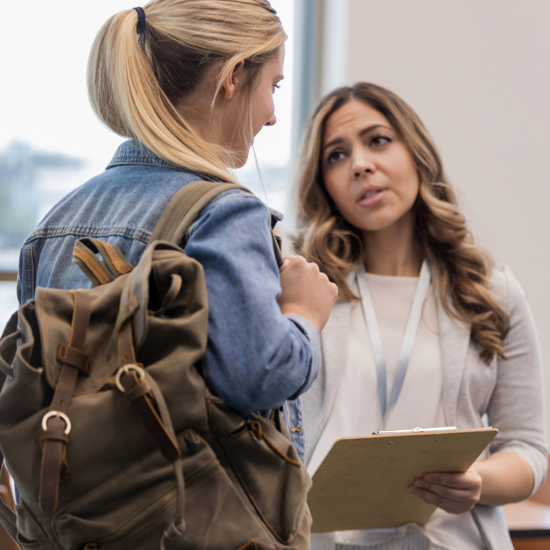 Two women talking in a business setting, one woman shows empathy for the other. 